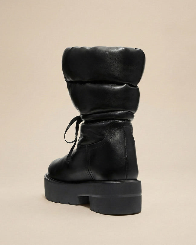 Chunky black puffer boot with thick sole and lace-up detail on neutral background