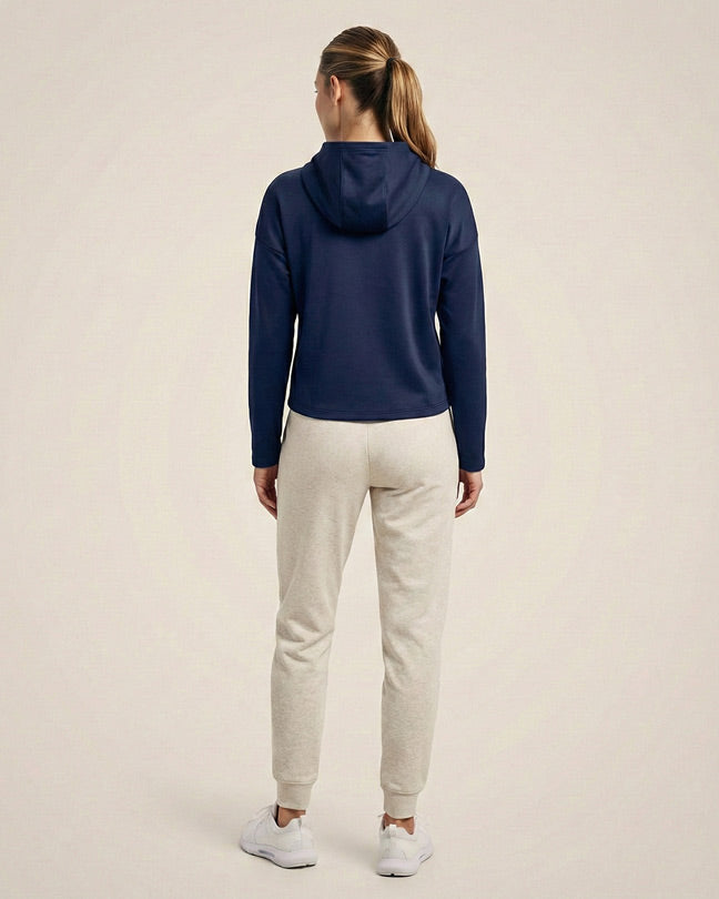 Woman in navy hoodie and light gray joggers, back view, casual loungewear fashion