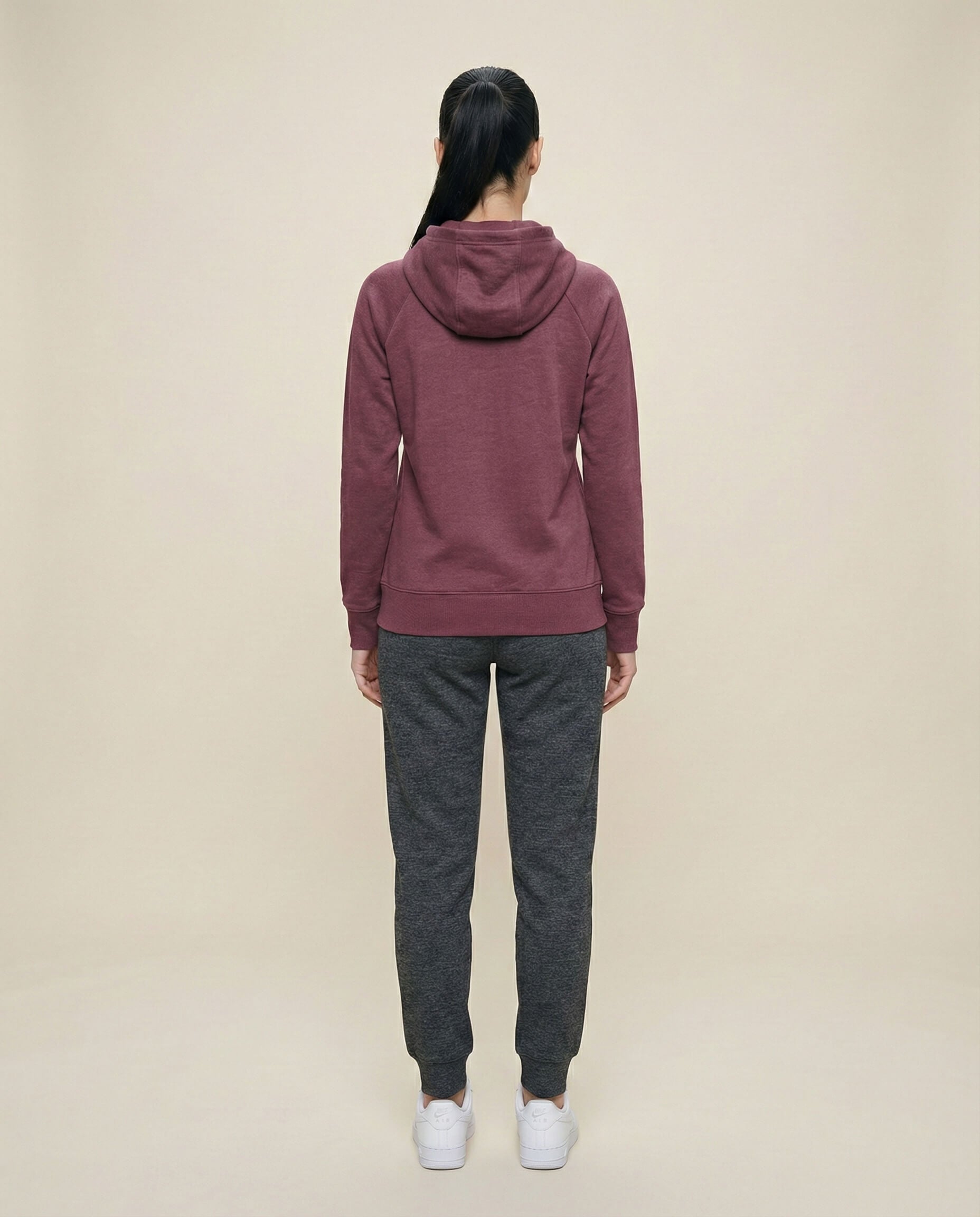 Woman in maroon hoodie and dark gray joggers, back view, casual loungewear outfit