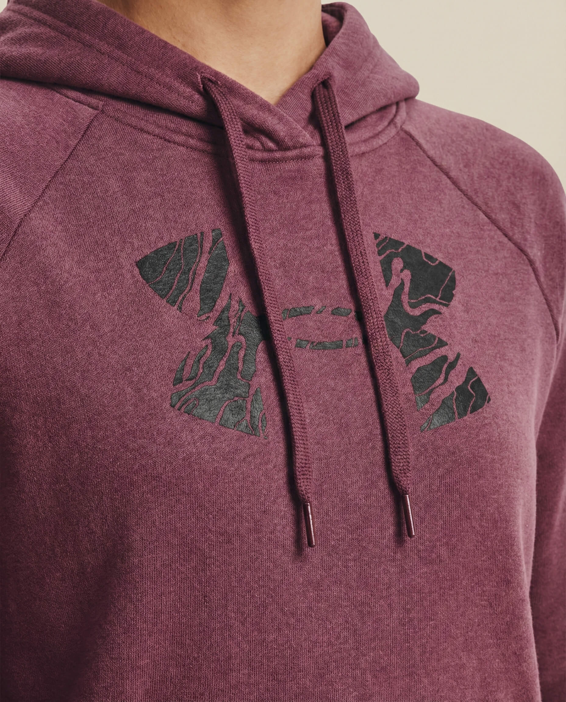 Maroon hoodie with black abstract logo and drawstring hood, close-up view