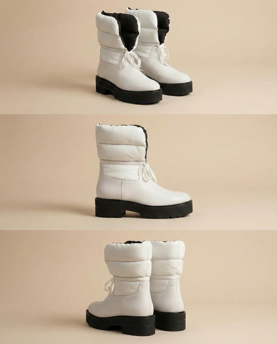 Chunky white winter boots with thick black soles and padded uppers on neutral background