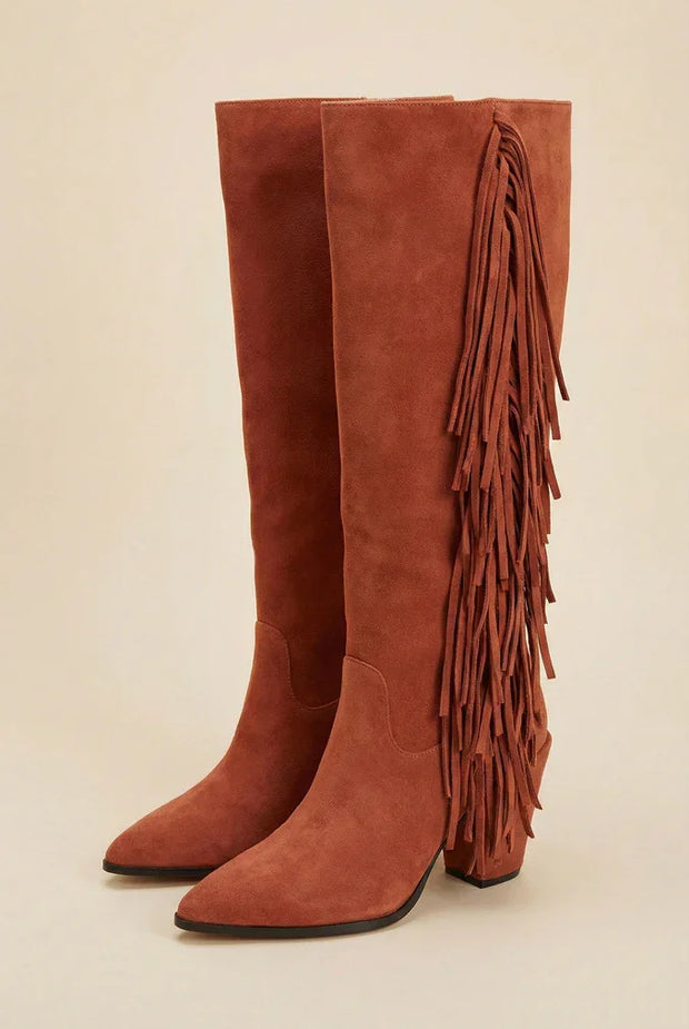 Brown suede knee-high boots with side fringe and block heel on neutral background