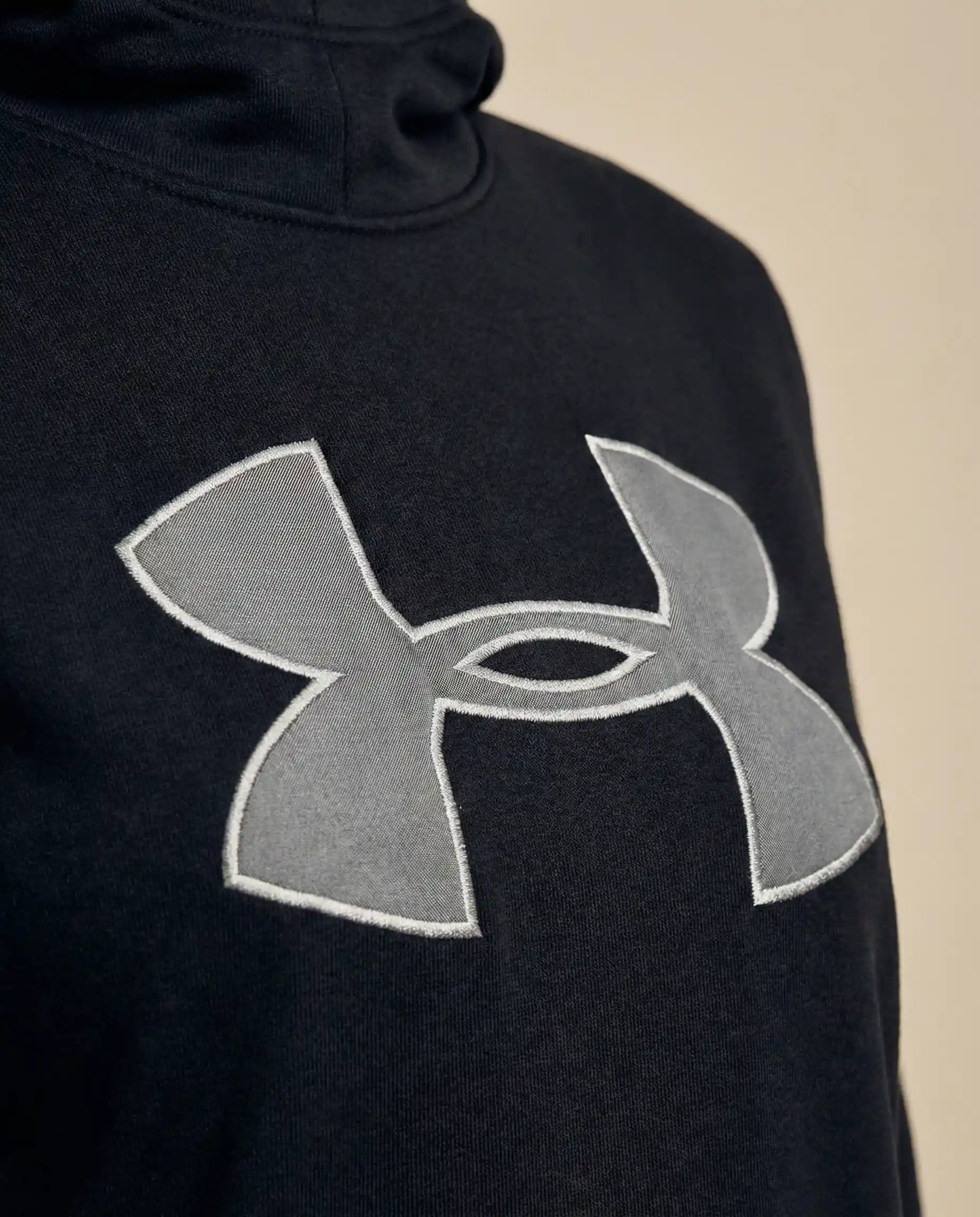 Black hoodie with large gray embroidered logo on chest