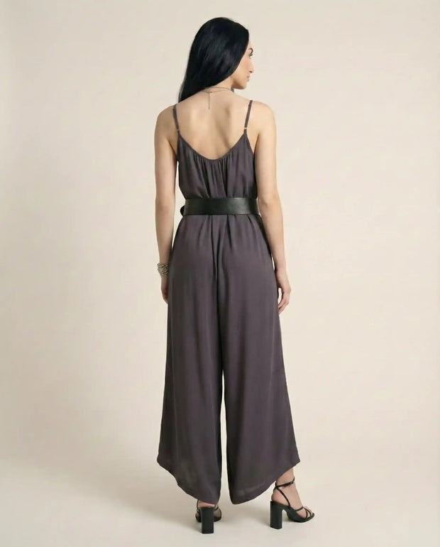 Woman wearing sleeveless wide-leg jumpsuit with black belt and heeled sandals, back view