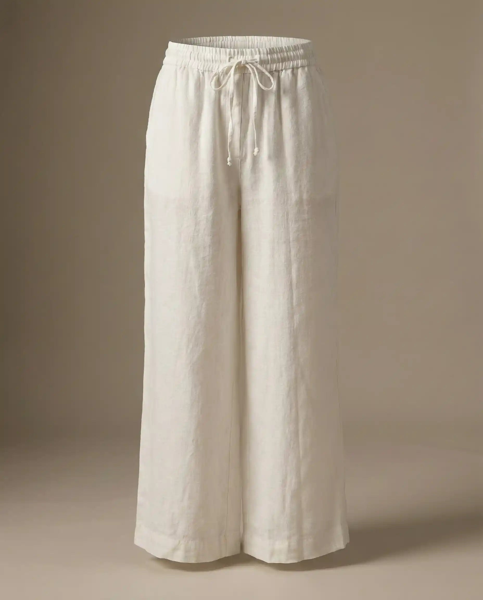 Wide leg white linen pants with elastic waistband and drawstring, neutral background