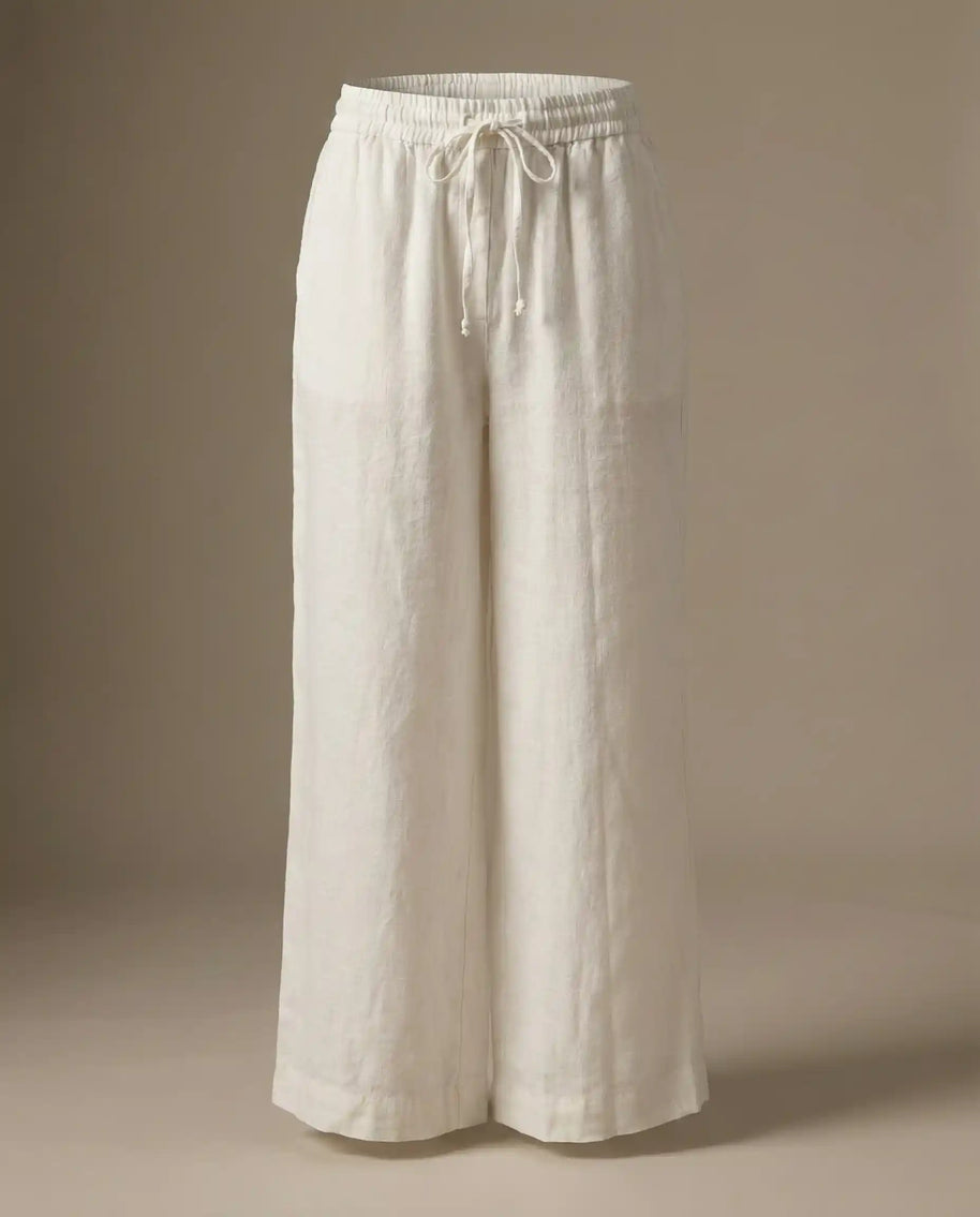 Wide leg white linen pants with elastic waistband and drawstring, neutral background