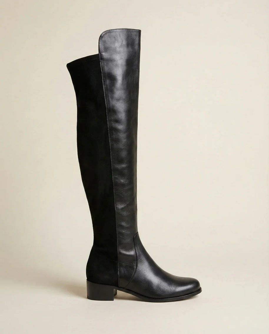 Black knee-high leather boot with low block heel on neutral background