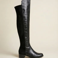 Black knee-high leather boot with low block heel on neutral background