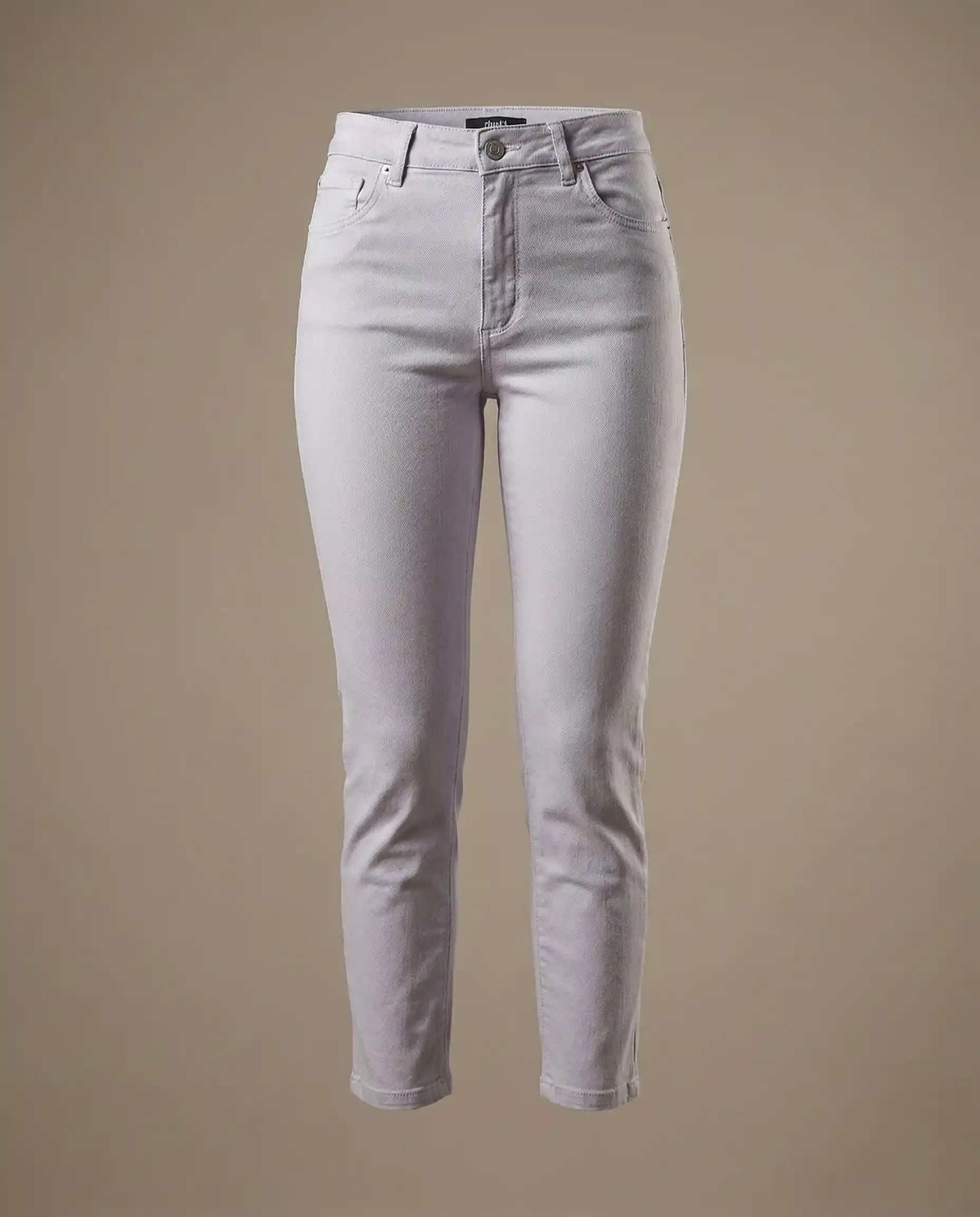 Light grey high-waisted skinny jeans with button closure and front pockets on beige background