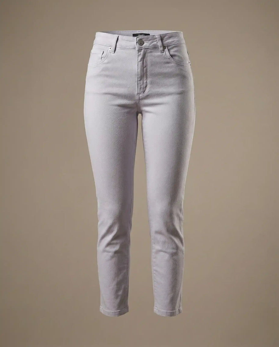 Light grey high-waisted skinny jeans with button closure and front pockets on beige background