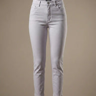 Light grey high-waisted skinny jeans with button closure and front pockets on beige background