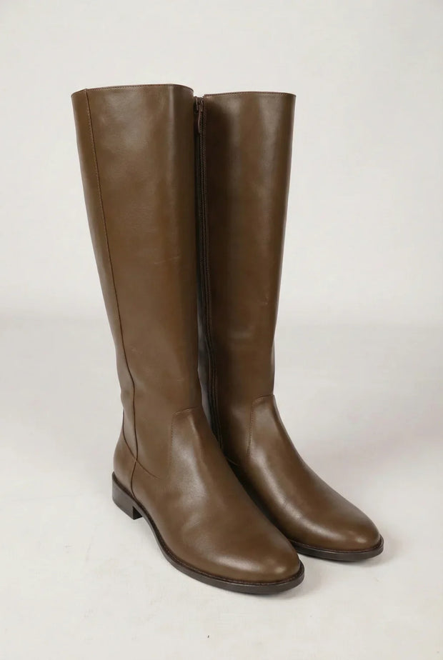 Pair of tall brown leather knee-high boots with side zippers on a plain background