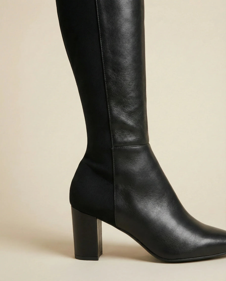 Black knee-high leather block heel boot on neutral background