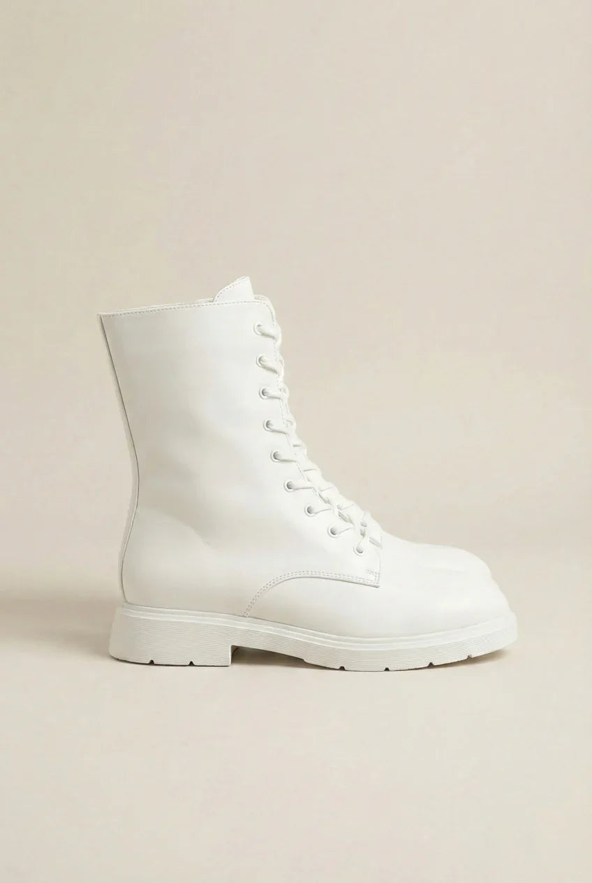 White lace-up combat boot with chunky sole on neutral background