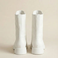 Pair of white mid-calf boots with chunky soles on a neutral background