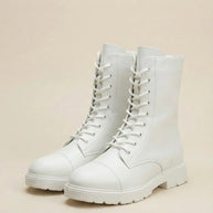 Pair of white lace-up combat boots with chunky soles on a neutral background