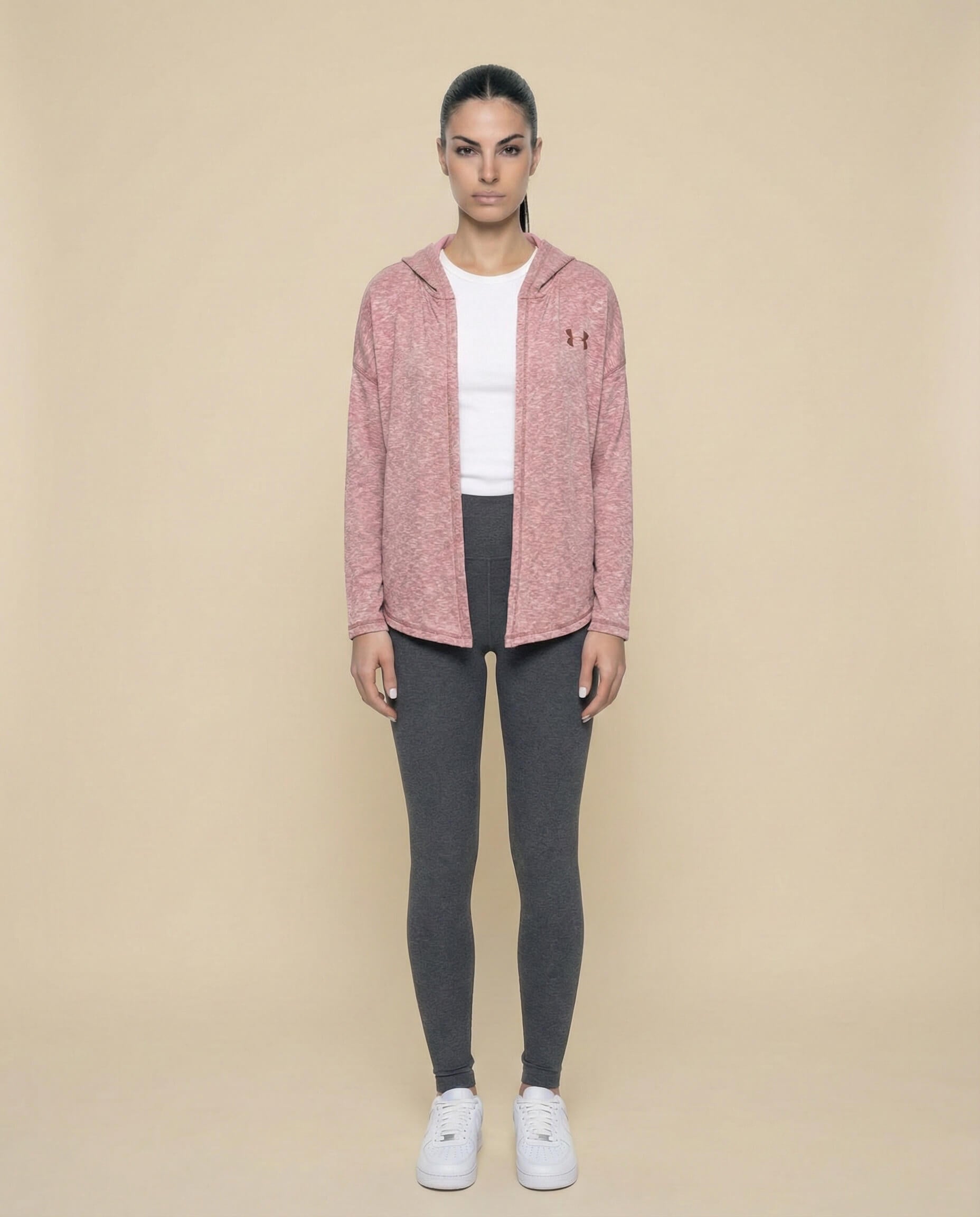 Woman in pink hooded jacket, white t-shirt, gray leggings, and white sneakers