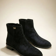 Pair of black suede ankle boots with low heels and gold SW logo on plain background