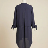 Back view of navy blue long-sleeve tunic dress with tie cuffs on mannequin