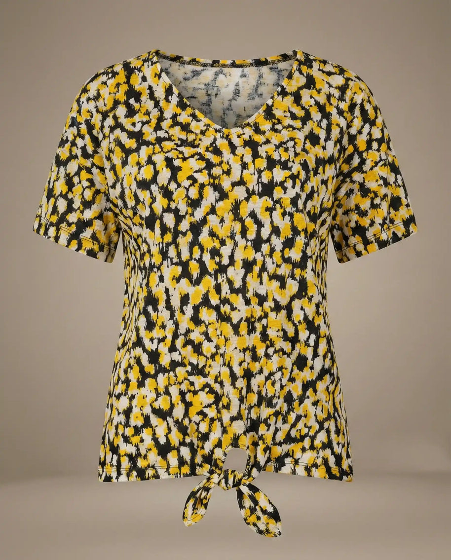 Yellow and black abstract print short sleeve V-neck tie-front blouse on plain background
