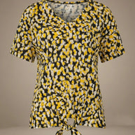 Yellow and black abstract print short sleeve V-neck tie-front blouse on plain background