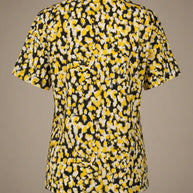 Back view of a short sleeve shirt with yellow, black, and white abstract floral pattern