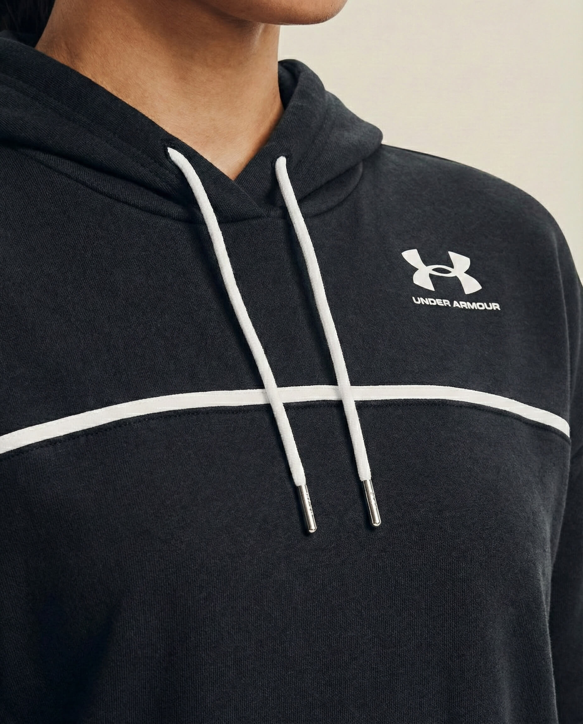 Close-up of black Under Armour hoodie with white drawstrings and logo on chest.