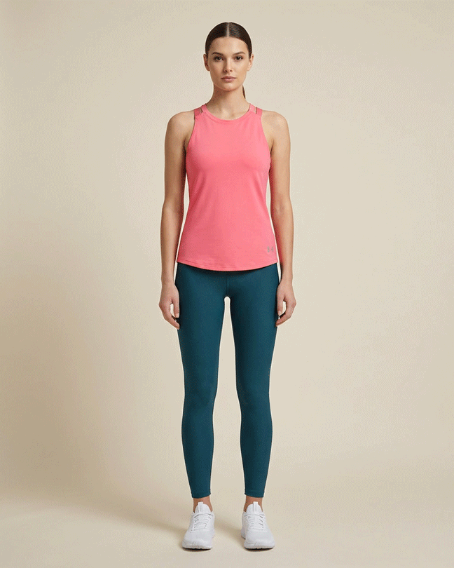 Woman wearing magenta athletic tank top and teal leggings, standing against beige background