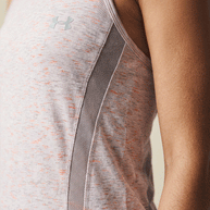 Light pink athletic tank top with mesh side panel, worn by person, close-up view