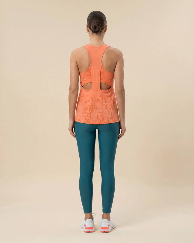 Woman wearing orange patterned racerback tank top and teal leggings, gym outfit