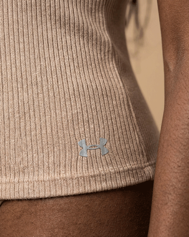 Close-up of beige ribbed Under Armour shirt on person's waist, athletic wear focus