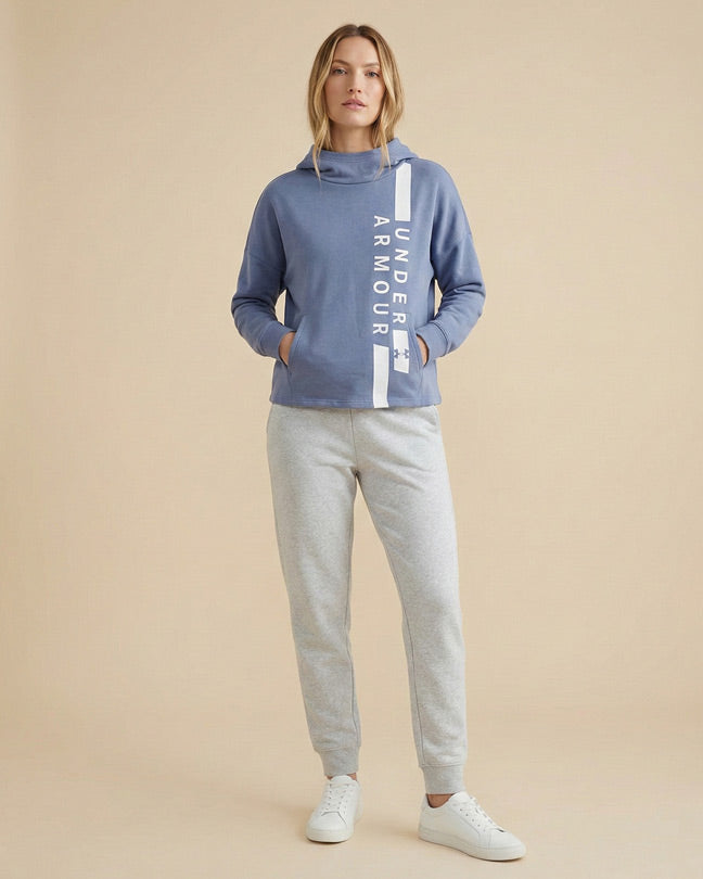 Woman in blue Under Armour hoodie and gray sweatpants with white sneakers, casual wear