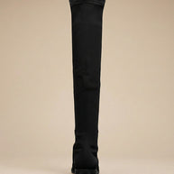 Black over-the-knee boot with low heel, rear view on neutral background