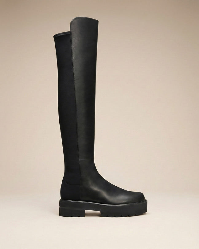 Black knee-high chunky sole boot with smooth leather finish, side view on neutral background