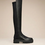 Black knee-high chunky sole boot with smooth leather finish, side view on neutral background