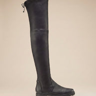 Black over the knee boot with flat sole and side tie detail on beige background