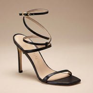 Black strappy high heel sandal with ankle wrap and square toe on beige background