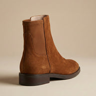Brown suede Chelsea boot with elastic side panel on neutral background