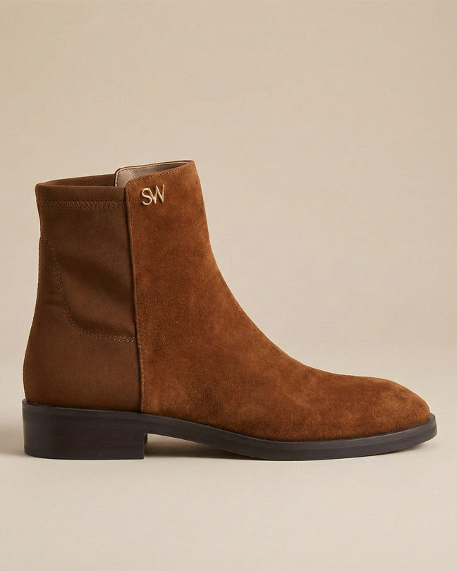 Brown suede ankle boot with low heel and gold SW logo on plain background
