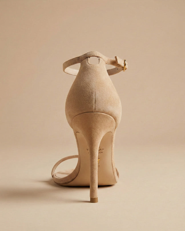Beige suede high heel sandal with ankle strap on a neutral background