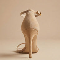 Beige suede high heel sandal with ankle strap on a neutral background
