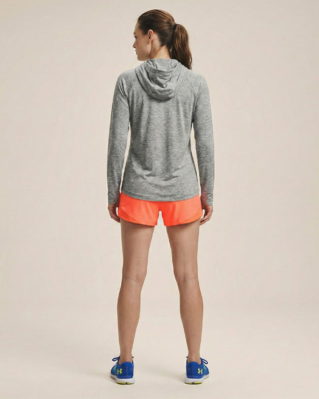 Woman wearing gray hooded athletic top and neon orange running shorts, back view