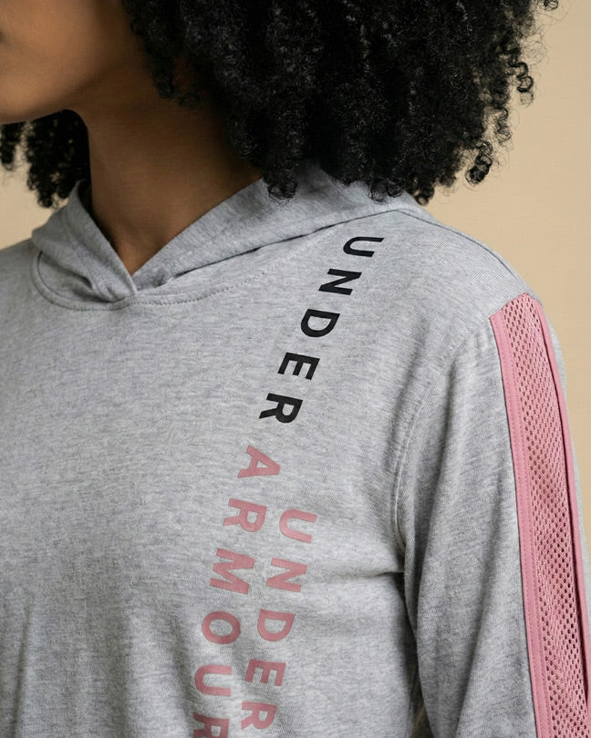 Gray Under Armour hoodie with pink mesh sleeve accents, worn by woman with curly hair