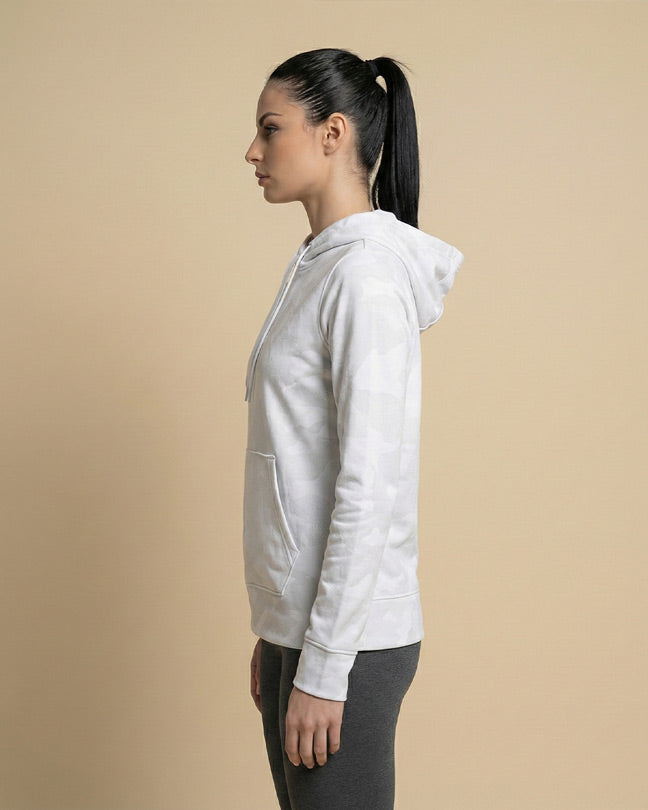 Woman in light gray camo print hoodie and dark leggings, side profile, neutral background