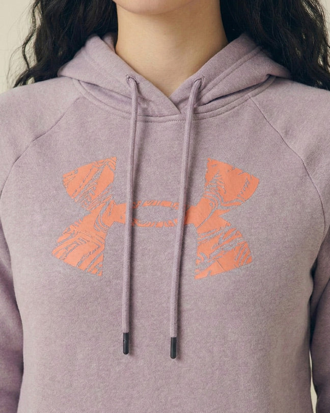 Lavender hoodie with orange graphic logo and drawstrings, worn by a woman
