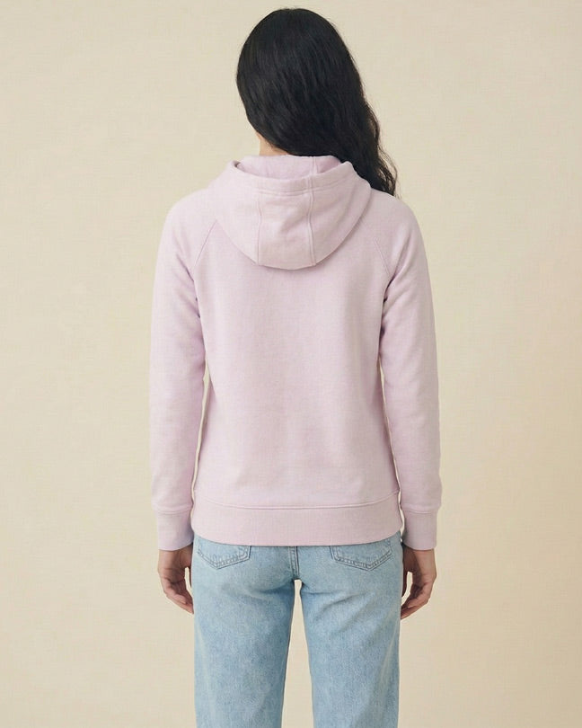 Back view of woman in light pink hoodie and blue jeans on neutral background