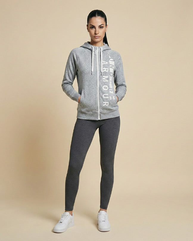 Woman wearing gray zip-up hoodie with white text and dark leggings, casual athletic style