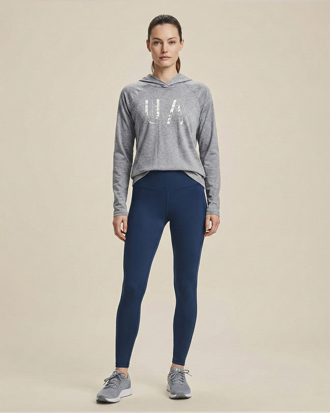 Woman in a grey hoodie with 'UA' print and navy blue leggings, athletic casual outfit