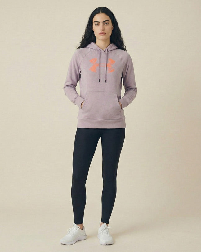 Woman wearing a light purple hoodie with orange print, black leggings, and white sneakers