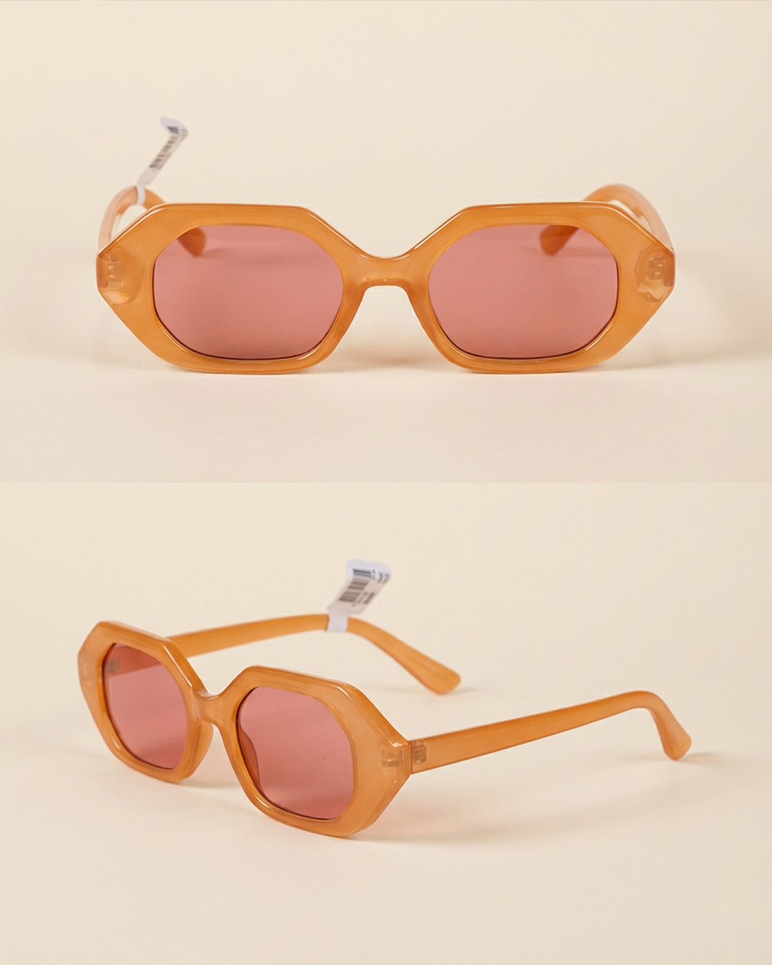 Geometric orange sunglasses with pink lenses on a neutral background